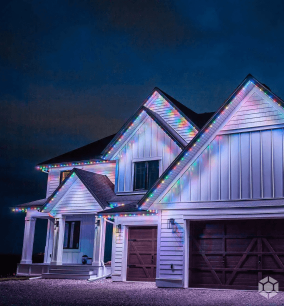 A house at night illuminated with Astoria Lighting. These lights are installed along the roofline and highlight the architectural features of the home.