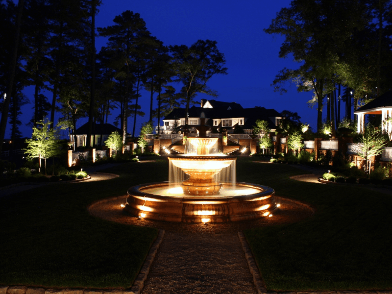driveway with water feature surrounded by outdoor landscape lighting