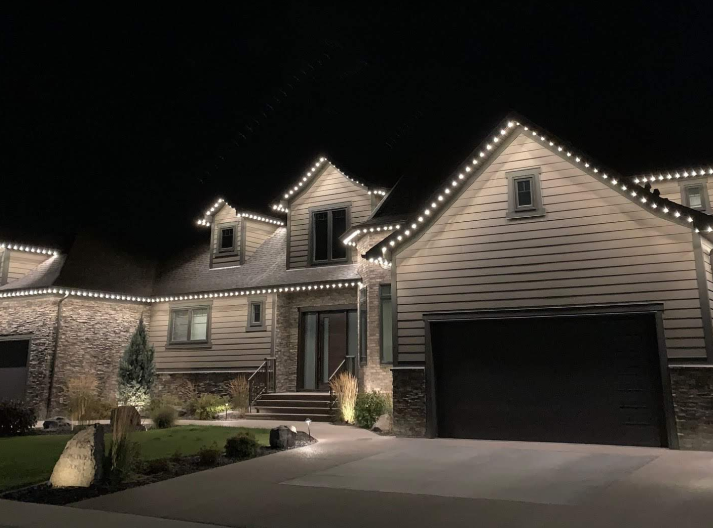 home with warm white lighting along the roofline