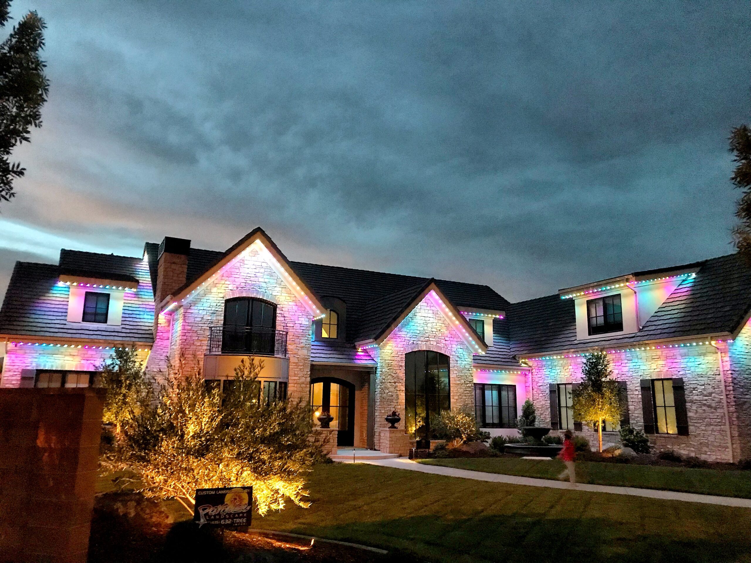 beautiful home with colorful permanent outdoor lights along the roofline