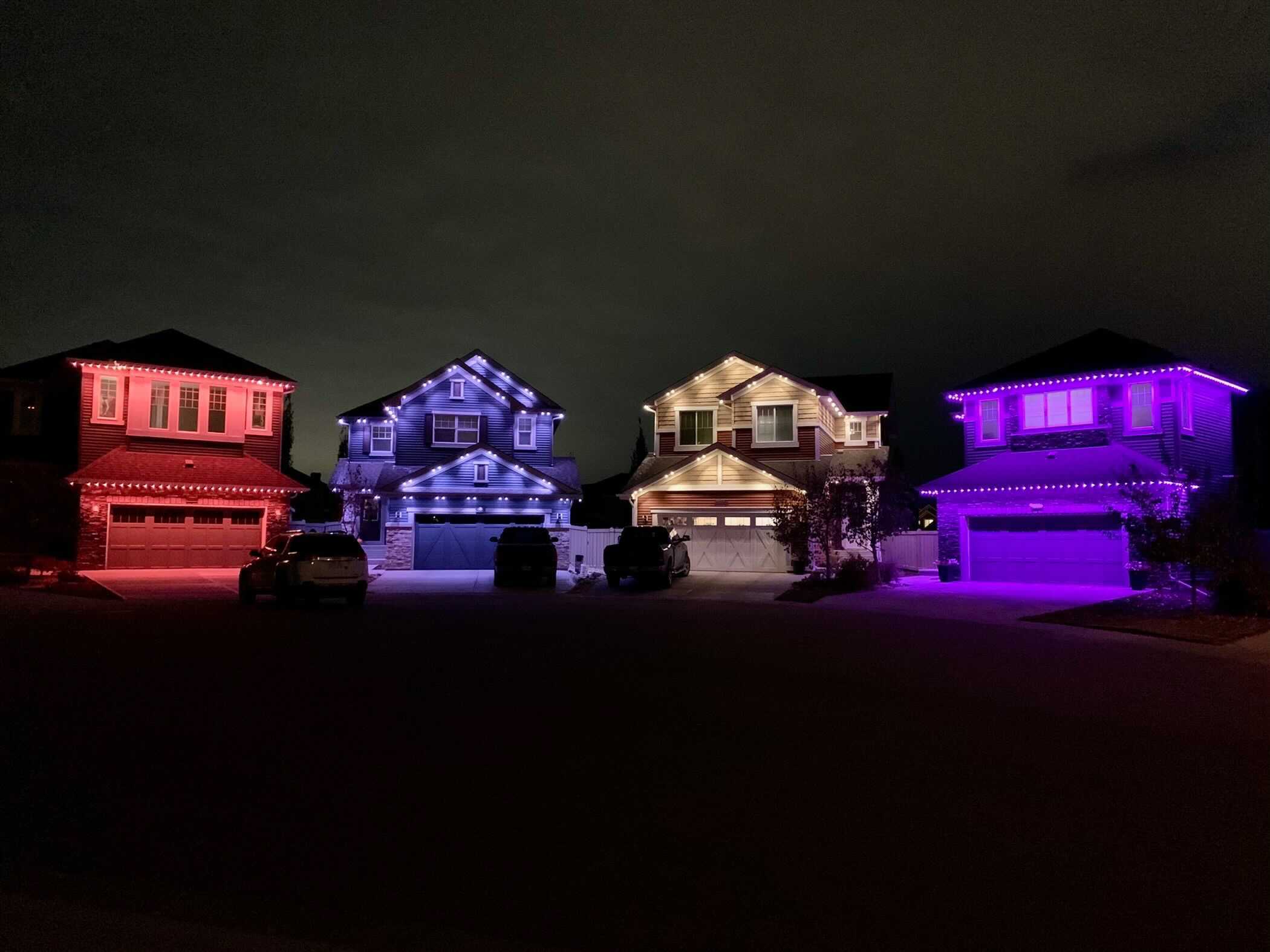 houses next to each other with different color permanent outdoor lights