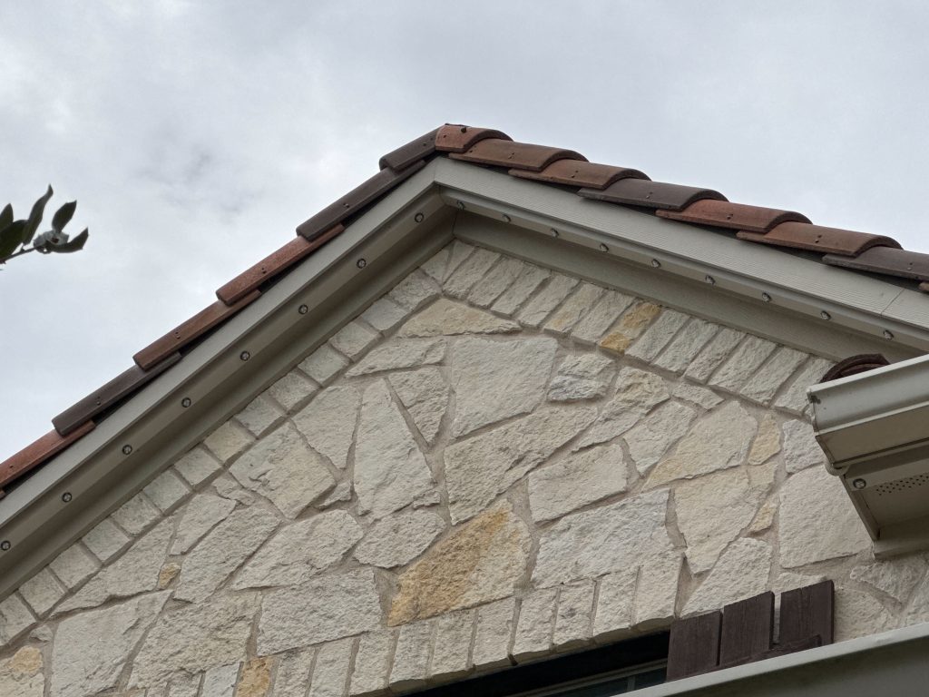 Residential stone house soffit line installed with Astoria's closed track permanent lighting system.