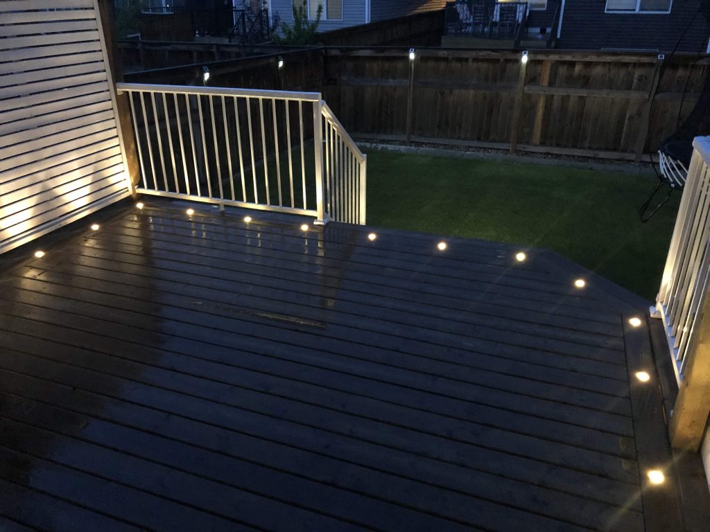 Residential backyard patio fitted with Astoria permanent landscape lights