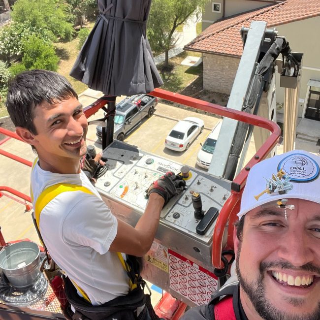 Astoria installer and general manager using a lift to install Astoria’s permanent lighting system along a multi-story hotel’s soffit line.