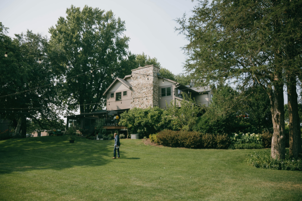 Person walking through backyard to help plan design for landscape lighting installation