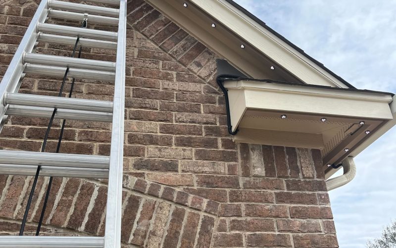 Brick exterior home featuring Astoria’s closed-track permanent lighting system along the soffit line, blending seamlessly with the home’s design and color palette.